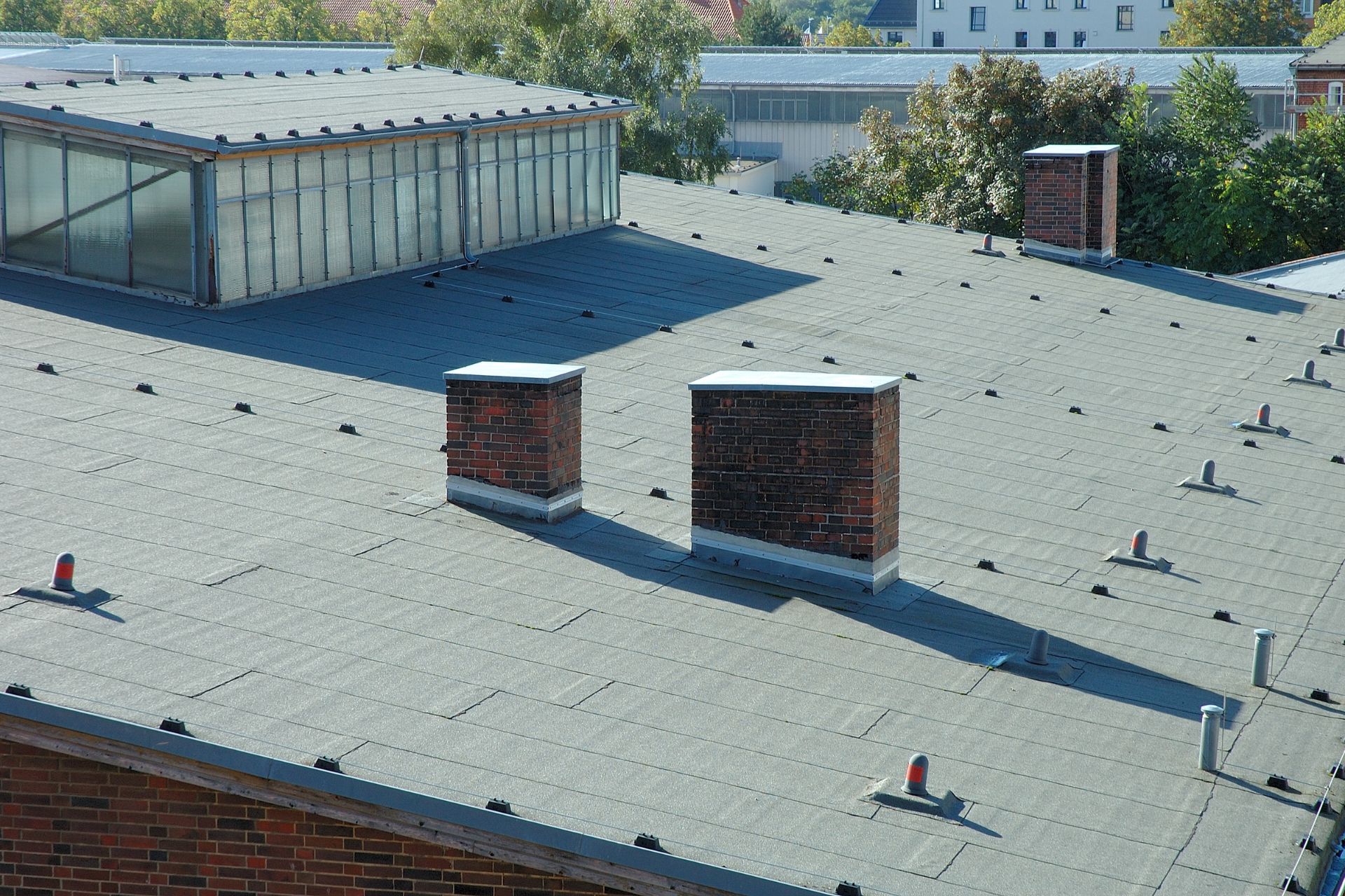 Stock photo of a flat roof with brick chimney stacks