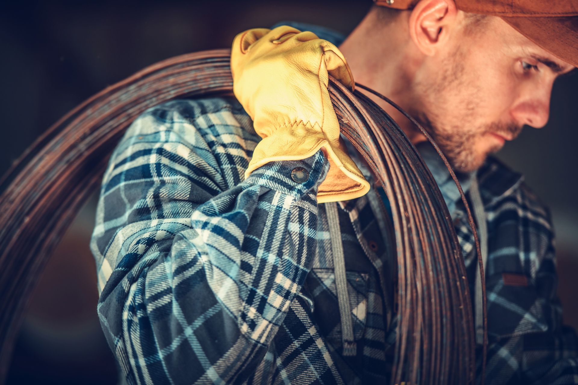 Stock photo of a construction worker carrying a coil of rebar wire